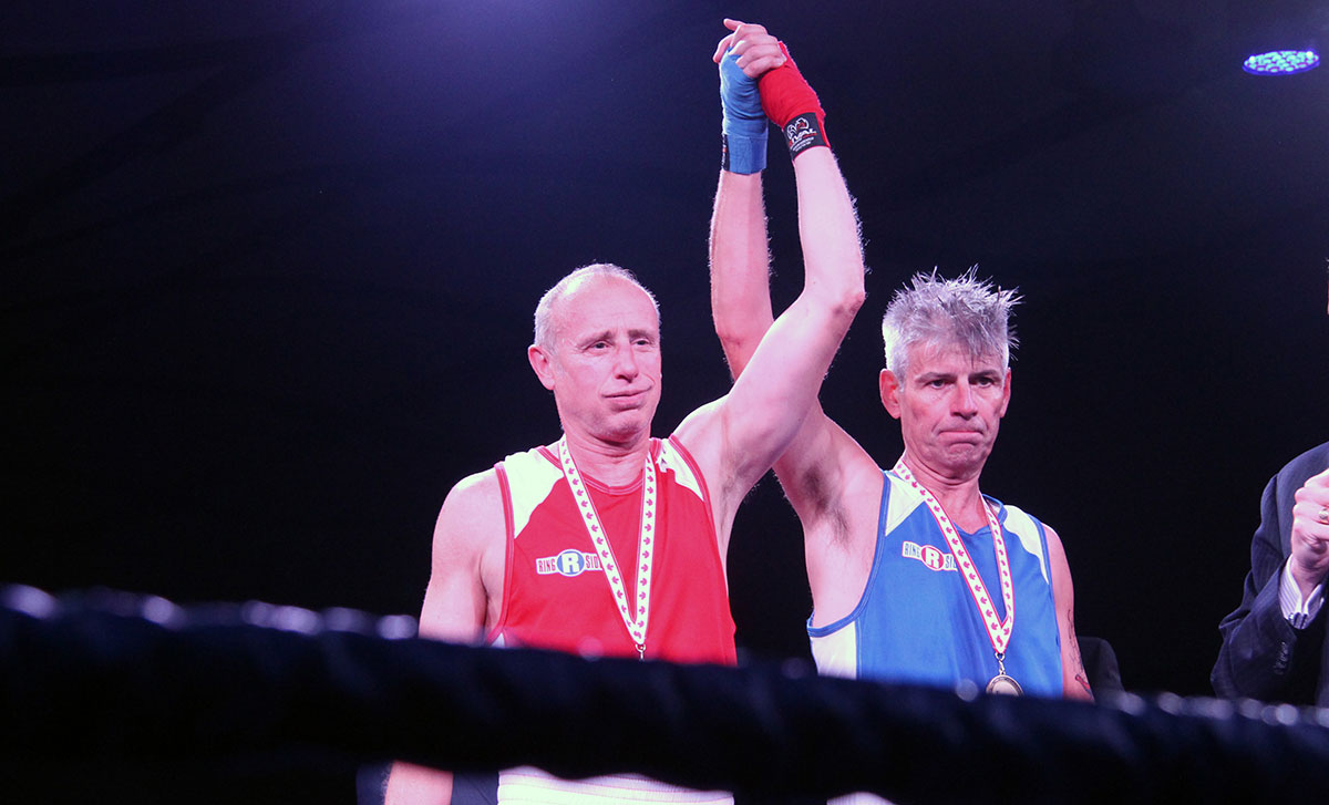 Micheal Burch and Steve McBurney symbolically raise their arms in the air together