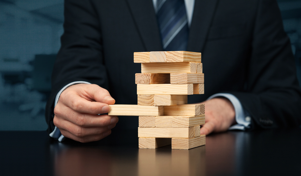 Businessman removing a block from a tower